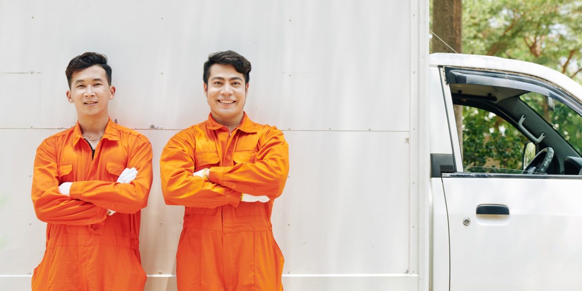 Smiling movers in orange uniform
